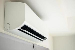 Air conditioner on white wall room interior background photo