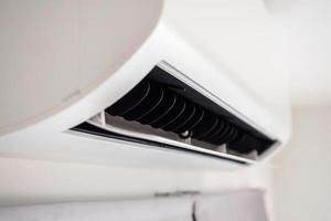 Air conditioner on white wall room interior background photo