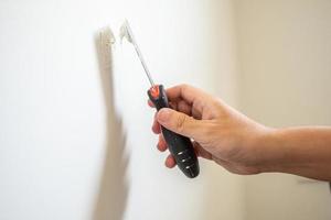 Man repairing crack white wall with spatula photo