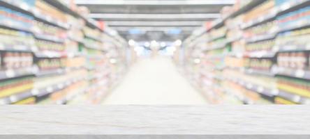 mesa de mármol con fondo borroso de la tienda de comestibles del supermercado con luz bokeh para la exhibición del producto foto