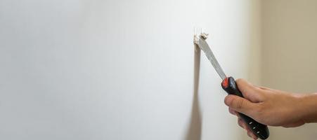 Man repairing crack white wall with spatula photo