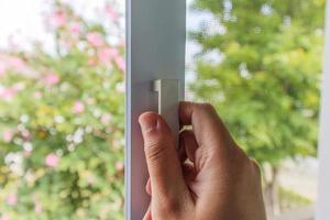 Hand hold mosquito net wire screen handle on house window photo