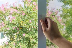 Hand hold mosquito net wire screen handle on house window photo