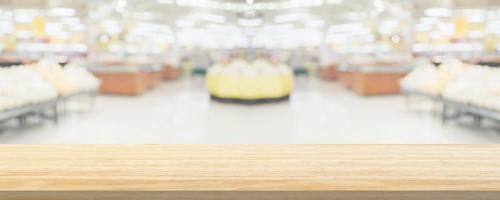 Wood table top with supermarket grocery store blurred defocused background with bokeh light for product display photo