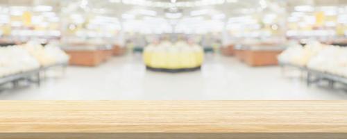 Wood table top with supermarket grocery store blurred defocused background with bokeh light for product display photo