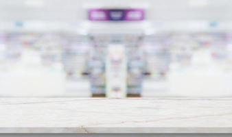 Empty white marble counter top with blur pharmacy drugstore shelves background photo