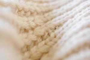 closeup beige knitted woolen fabric texture background photo