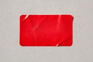 Red paper sticker label on cardboard background photo