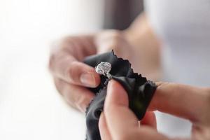 joyero limpieza anillo de diamantes de joyería con paño de tela foto