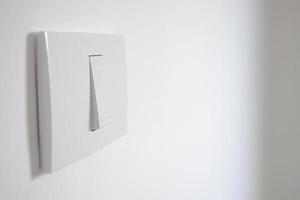 white lighting switch on concrete wall photo