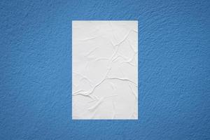 Blank white wheatpaste glued paper poster mockup on concrete wall background photo