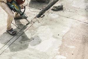 trabajador de la construcción con martillo perforador de superficie de hormigón foto