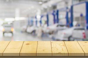 Empty wood table top with car service centre auto repair workshop blurred background photo