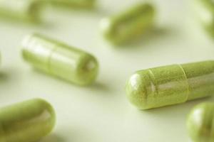 Herbal medicine capsules on white background photo