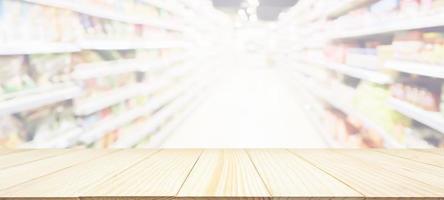 mesa de madera con fondo borroso de la tienda de comestibles del supermercado con luz bokeh para la exhibición del producto foto