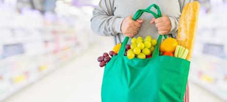 Woman hold grocery shopping bag in supermarket photo