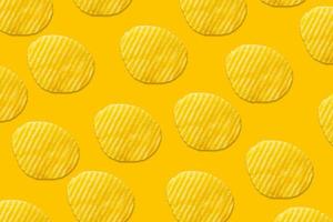 Potato chips pattern on yellow background top view flat lay photo