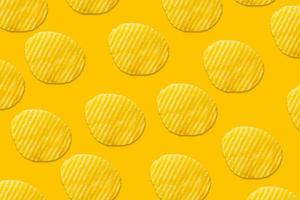 Potato chips pattern on yellow background top view flat lay photo