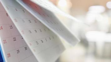 Close up white paper desk calendar with blurred bokeh background appointment and business meeting concept photo