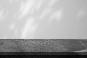 Marble table with tree shadow drop on white wall background for mockup product display photo