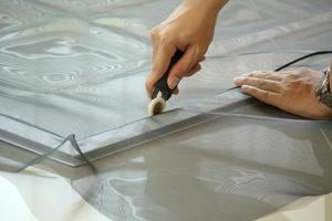 man install mosquito net wire screen on house window protection against insect photo