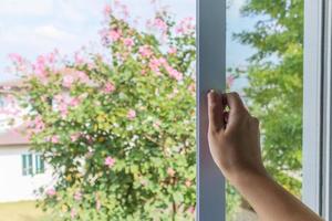 Hand hold mosquito net wire screen handle on house window photo