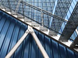 Close-up view of galvanised steel staircases against a blue metakl cladding building photo