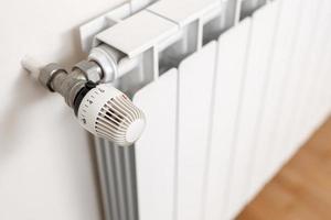 Heating radiator thermostat showing maximum temperature. Concept of waste and expenditure in heating photo