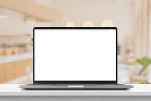 Laptop with blank screen on marble table with cafe coffee shop blur background photo