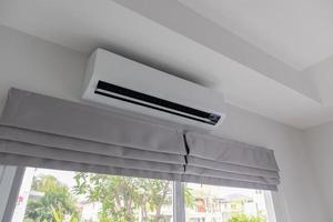 Air conditioner on white wall room interior background photo