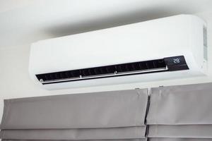 Air conditioner on white wall room interior background photo