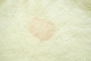 dirty color stain on yellow fabric texture background photo