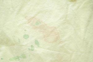 dirty color stain on yellow fabric texture background photo