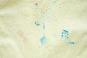 dirty color stain on yellow fabric texture background photo