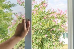 Hand hold mosquito net wire screen handle on house window photo