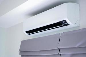 Air conditioner on white wall room interior background photo