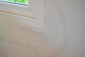 house wall near the window with some water stain show peeling paint photo