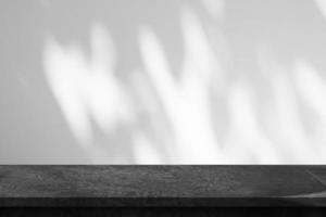 Marble table top with tree shadow drop on white wall background for mockup product display photo