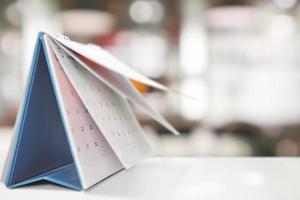 desk calendar on table with blurred bokeh background appointment and business meeting concept photo