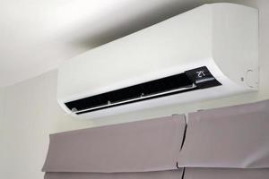 Air conditioner on white wall room interior background photo