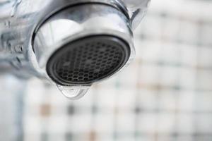 Close up faucet with water drop photo