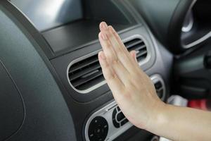 hand checking air conditioner system inside the car photo