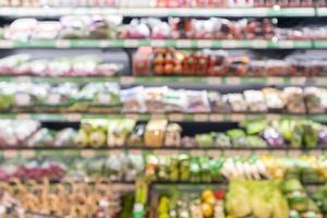 Grocery store shelves with fruits and vegetables blurred background photo