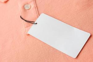 etiqueta de etiqueta de ropa blanca en blanco sobre fondo de textura de tela rosa foto