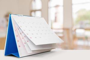 desk calendar on table with blurred bokeh background appointment and business meeting concept photo