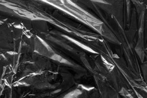 transparent plastic bag film wrap overlay texture on black background photo