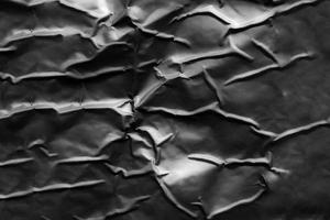 black crumpled and creased plastic poster texture background photo