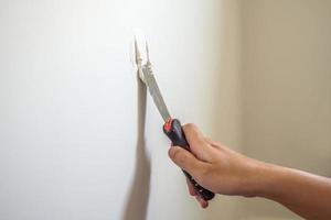 Man repairing crack white wall with spatula photo