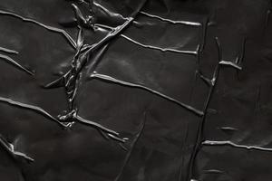 black crumpled and creased plastic poster texture background photo