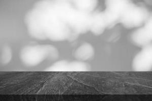 Marble table top with tree shadow drop on white wall background for mockup product display photo